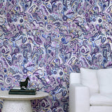 White couch and marble side table against wallpaper in abstract brushstroke design in shades of purple and black accents. 