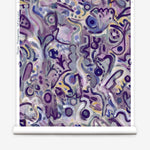 Wallpaper roll in abstract brushstroke design in shades of purple and black accents. 