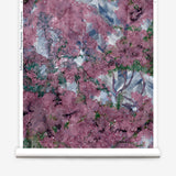 Wallpapper roll in a painterly tree print in purple, green and brown.