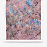 Wallpapper roll in a painterly tree print in pink, orange, gray and blue.
