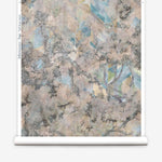 Wallpapper roll in a painterly tree print in cream, gray and turquoise.