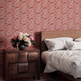 Bedroom scene with wooden furniture against a wallper in an undulating abstract watercolor motif in pink, orange and grey. 