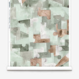 Wallpaper roll in an geometric puzzle piece watercolor pattern in sage green, grey and brown. 