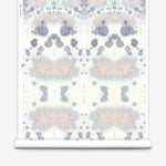 Wallpaper roll in a watercolor inkblot print in pastel pink and purple on a cream field.