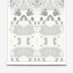 Wallpaper roll in a watercolor inkblot print in shades of blue-gray on a cream field.