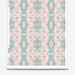 Partially unrolled wallpaper yardage in a painterly gometric stripe in gray, blue and green on a pink field.
