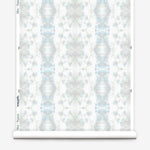 Partially unrolled wallpaper yardage in a painterly gometric stripe in gray, blue and green on a white field.
