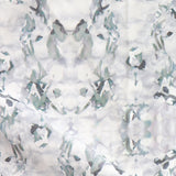 Detail of fabric in a watercolor paint blotch print in gray and turquoise on a white field.