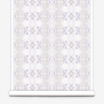 Partially unrolled wallpaper yardage in a striped ink blot print in shades of tan and purple on a cream field.