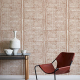 Modern brown chair with black frame against a brown geometric wallpaper