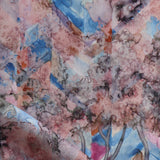 Detail of fabric in a painterly tree print in pink, orange, gray and blue.
