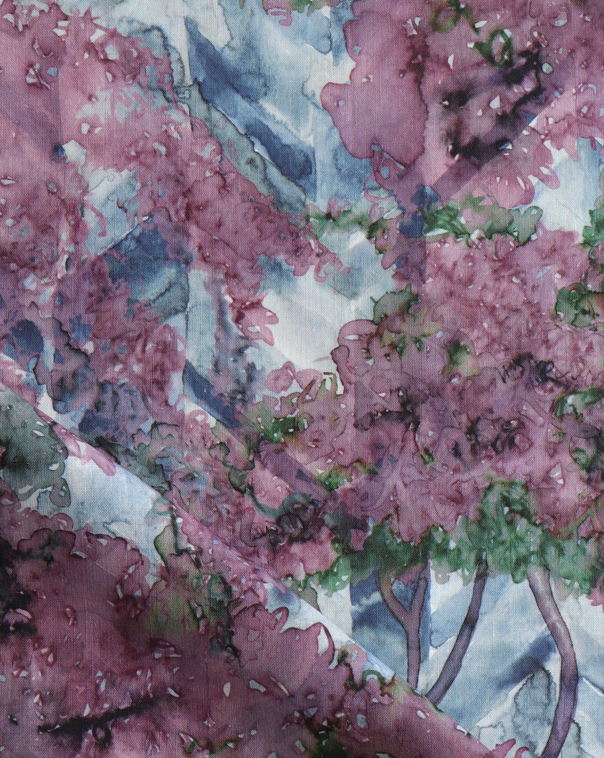 Detail of fabric in a painterly tree print in purple, green and brown.