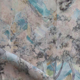 Detail of fabric in a painterly tree print in cream, gray and turquoise.