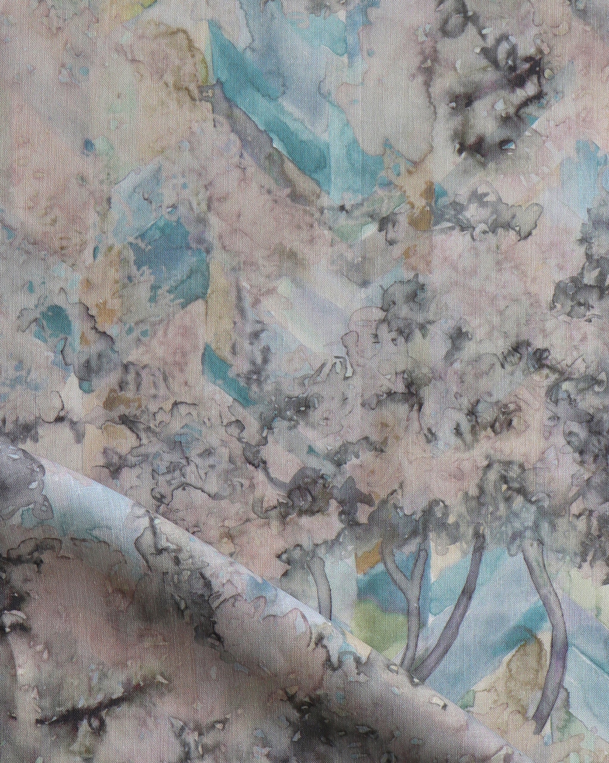 Detail of fabric in a painterly tree print in cream, gray and turquoise.
