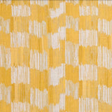 Detail of fabric in an abstract check print in shades of yellow and white.