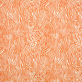 Detail of fabric in a playful animal print in orange on a white field.