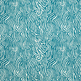 Detail of fabric in a playful animal print in turquoise on a white field.