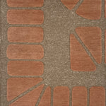 Handknotted carpet in a raised geometric design in peach on a taupe field.