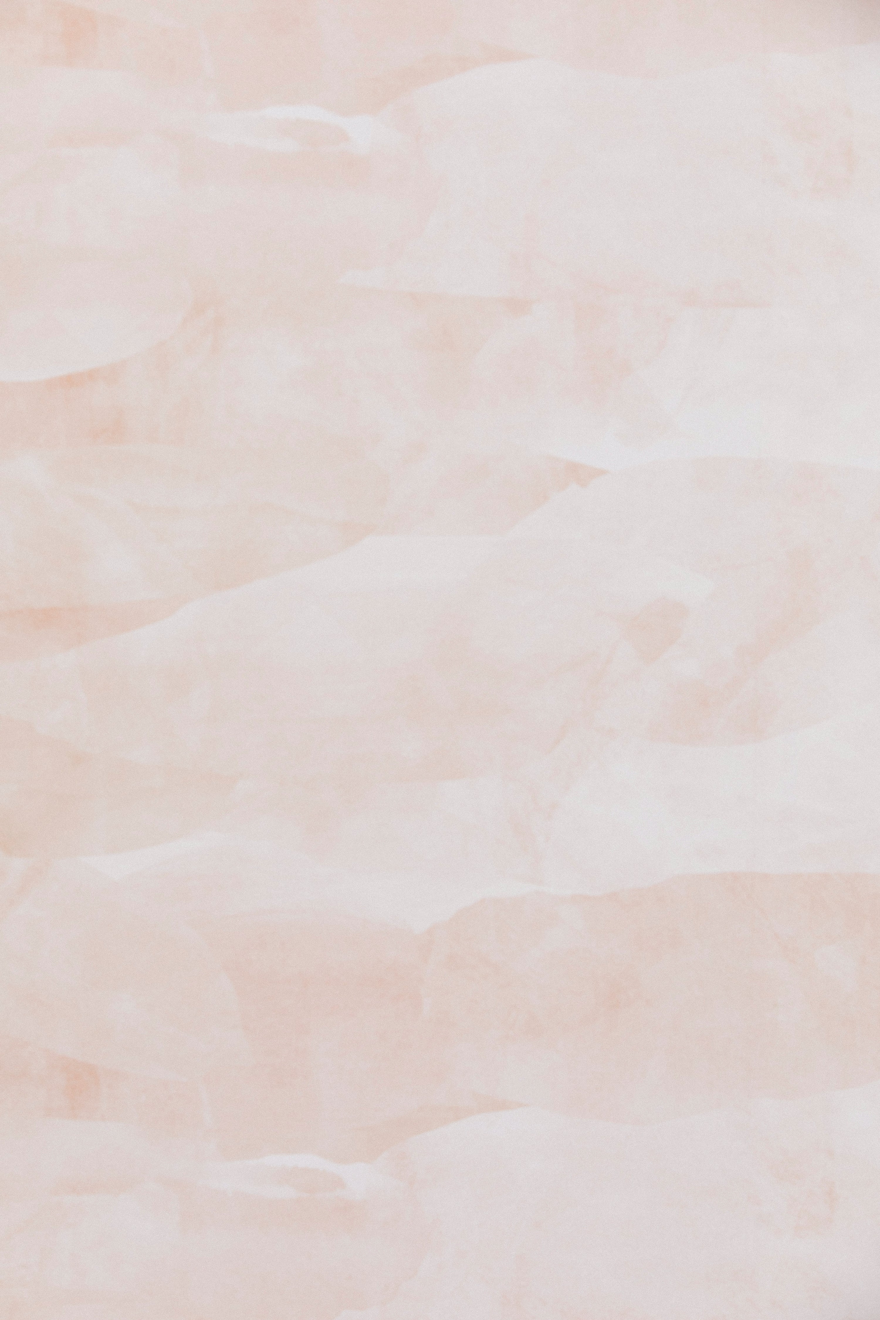 Detail of wallpaper in an abstract textural pattern in shades of white and pink.