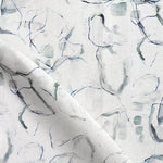 Detail of draped fabric in a watercolor painterly print in shades of gray, purple and cream.