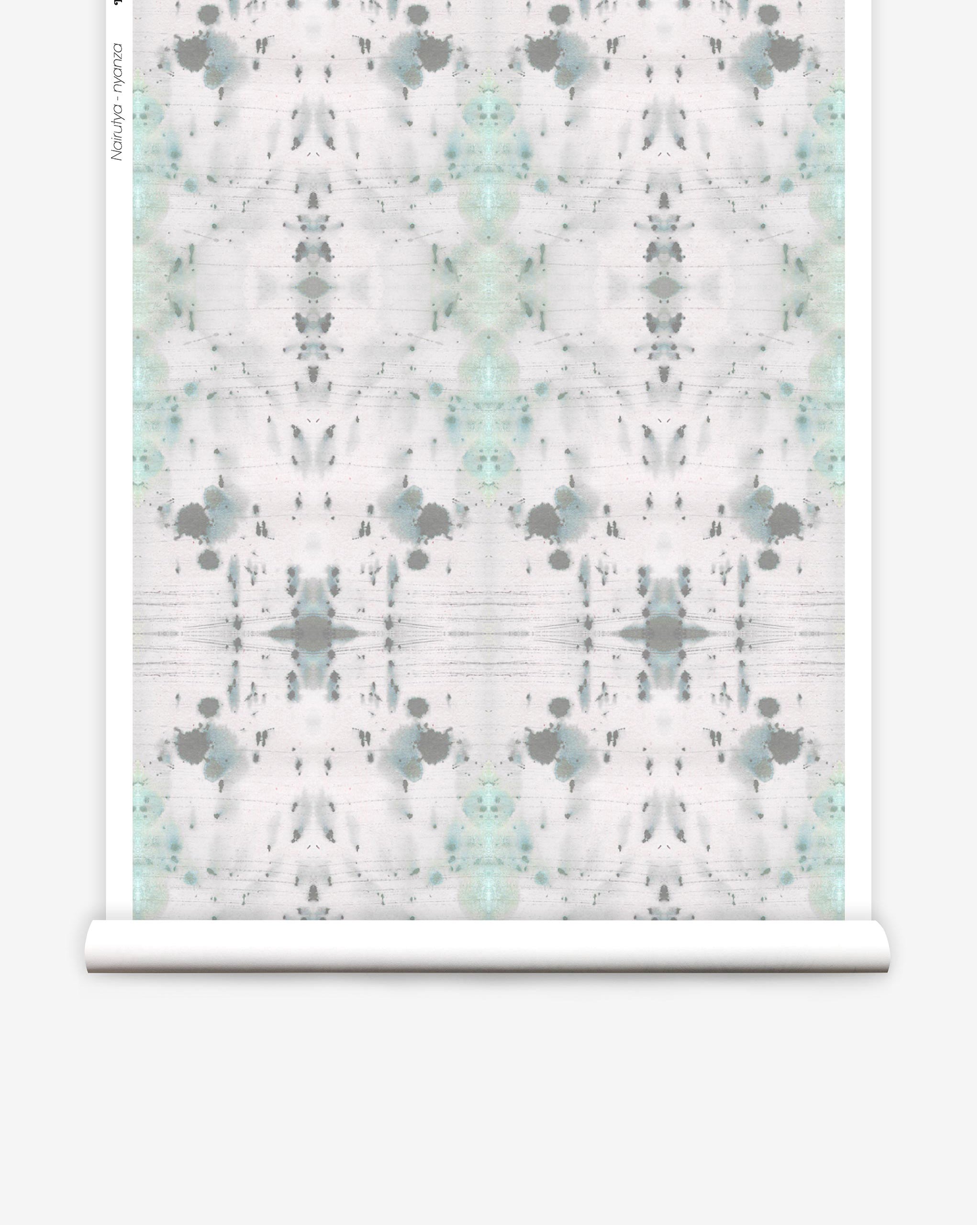 Partially unrolled wallpaper yardage in a watercolor ink blot print in gray and green on a cream field.