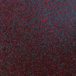 Close up of paint splatters in red, blue and black.