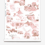 Partially unrolled wallpaper yardage in a playful illustrated city print in pink, brown and white.