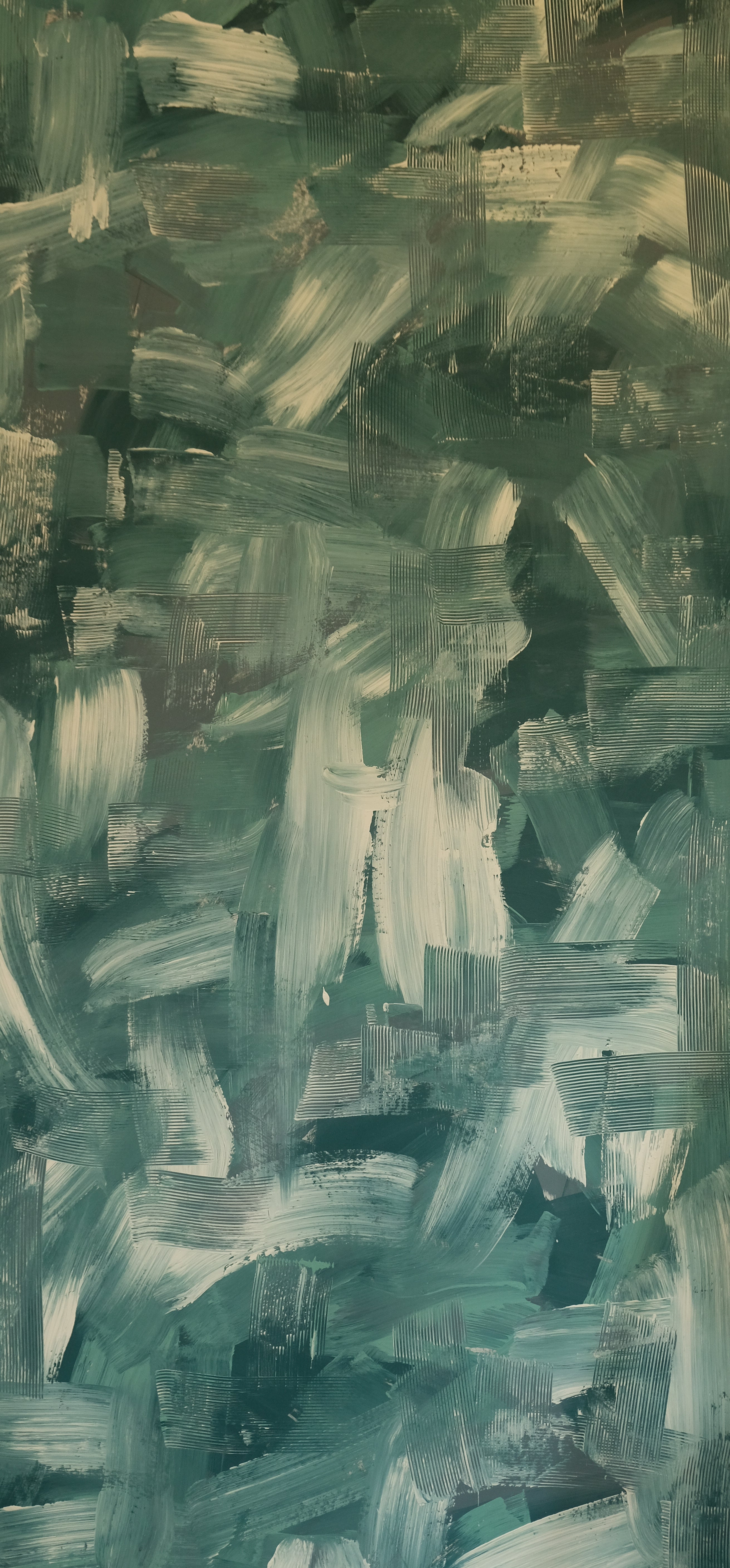 Detail of wallpaper in an abstract paint print in shades of green, turquoise and cream.
