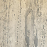 Detail of wallpaper in a textural paint splatter print in shades of gray and cream.