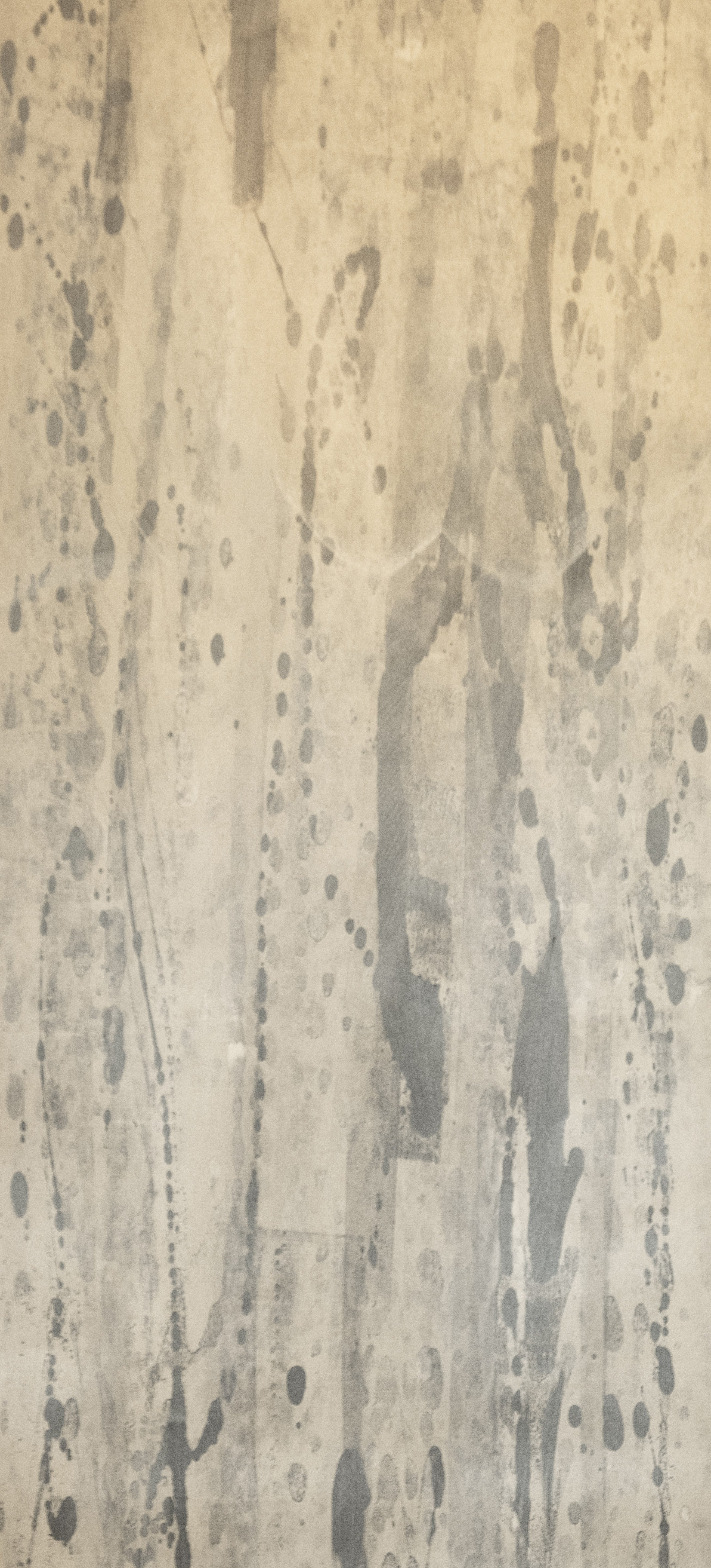Detail of wallpaper in a textural paint splatter print in shades of gray and cream.