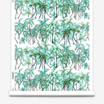 Partially unrolled wallpaper yardage in a painterly palm tree stripe print in green, gray and white.