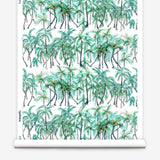 Partially unrolled wallpaper yardage in a painterly palm tree stripe print in green, gray and white.