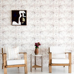 A modernist living tableau with a wall papered in a painterly palm tree stripe print in cream, gray and white.