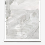 Partially unrolled wallpaper yardage in a watercolor painterly print in shades of gray and cream.