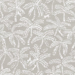 Detail of fabric in a playful palm tree and monkey print in white on a light gray field.