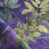 Fabric with floral pattern with green leaves on a purple background