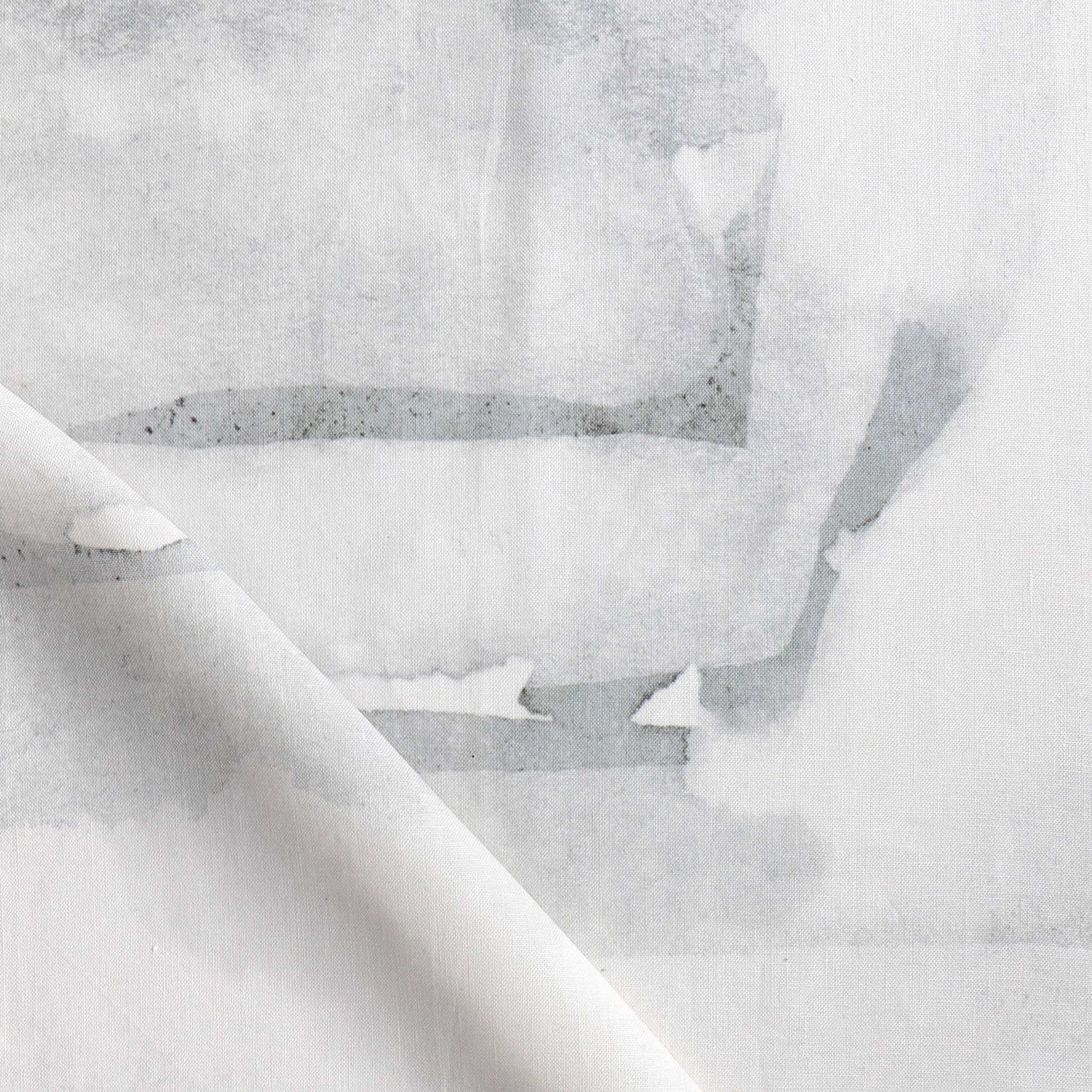Draped fabric yardage in a watercolor watercolor print in shades of gray on a white field.