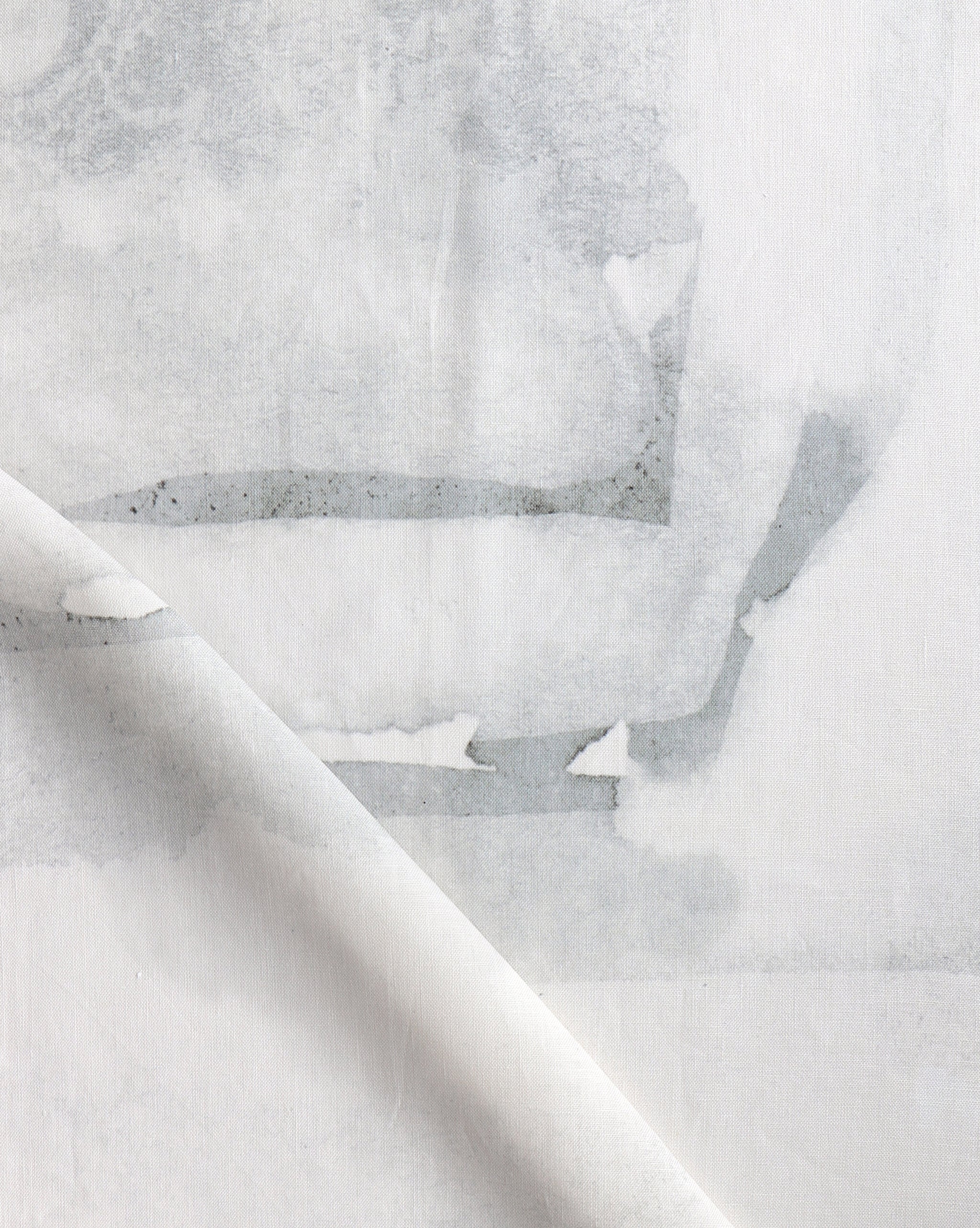 Draped fabric yardage in a watercolor watercolor print in shades of gray on a white field.