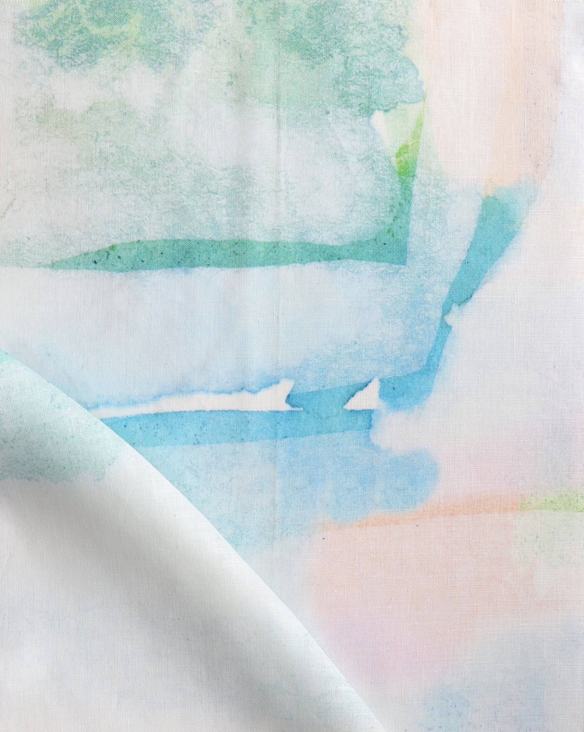 Draped fabric yardage in a watercolor watercolor print in shades of pastel and turquoise on a white field.