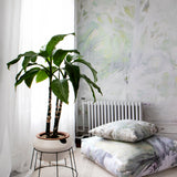 Room interior with a plant on a small table, radiator, and patterned cushions.