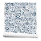 Partially unrolled wallpaper in a dense hand-drawn geometric motif in shades of navy on a white background.