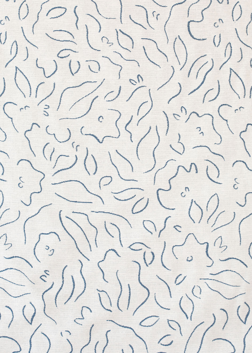 Detail of fabric in a minimalist floral print in navy on a cream field.