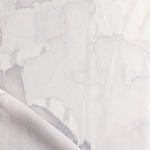 Draped fabric yardage in a watercolor watercolor print in shades of gray and purple on a white field.