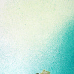 A vase of flowers stands in front of a wall covered in an abstract ombré paint splatter print in green, turquoise and white.
