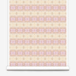 Partially unrolled wallpaper yardage in a gridded paint splatter print in shades of pink, yellow, cream and white.