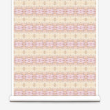 Partially unrolled wallpaper yardage in a gridded paint splatter print in shades of pink, yellow, cream and white.