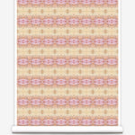 Partially unrolled wallpaper yardage in a gridded paint splatter print in shades of pink, orange, yellow and white.