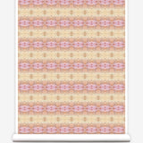 Partially unrolled wallpaper yardage in a gridded paint splatter print in shades of pink, orange, yellow and white.