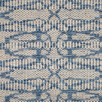 Flatweave rug in an abstract lattice design in blue on a cream field.