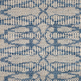 Flatweave rug in an abstract lattice design in blue on a cream field.
